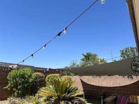 Sunshade sail over dog run area of backyard