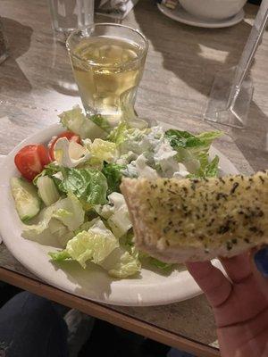 Bread, salad with creamy feta dressing, and a glass of Greek wine