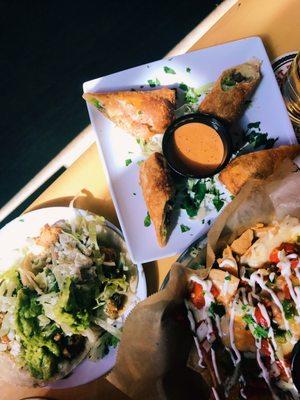 Happy hour chicken tacos ($3), short rib egg rolls ($5), and loaded nachos ($5)