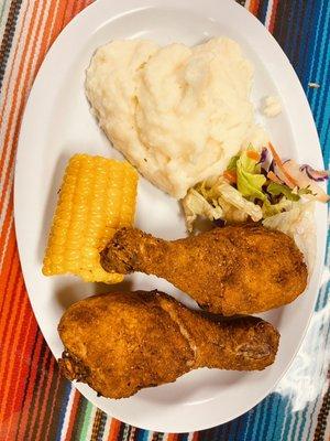 Chicken drumstick platter mashed potatoes corn and a side salad