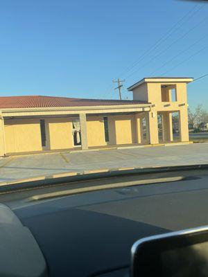 Building where business is located. Door with white curtain is entrance.