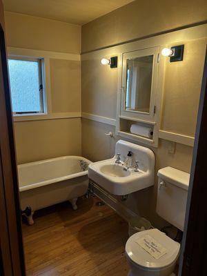 Restored bathroom with tub from another unit, old sink from basement and period appropriate toilet donated