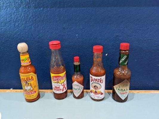 Great selection of hot sauces on the table.