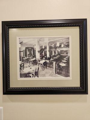 An old black and white framed photograph of when this building held a fine dining restaurant.