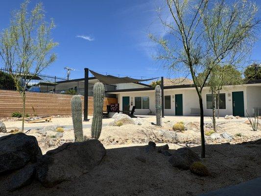 Exterior desert patio with pool hiding in the background.