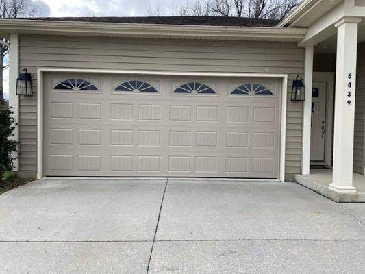 Modern windows really stand out on this beautiful tan garage door.