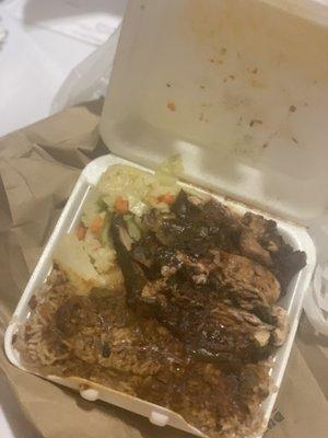 Jerk chicken platter with rice and pea, and cabbage.