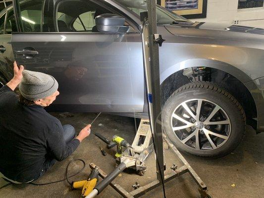 Before-Doug working his magic, pushing out the dent without removing the door panel.