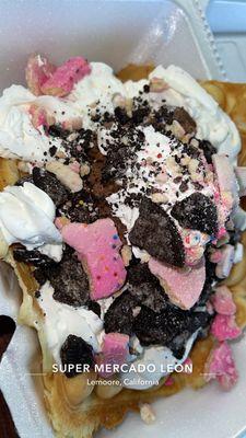 Bubble waffle w/ peanut butter fudge ice cream topped w/ whipped cream , Oreos , and frosted animal crackers