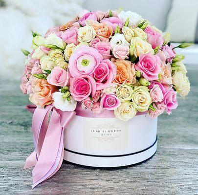 Arrangement of Roses and Ranunculus in a trendy hat box