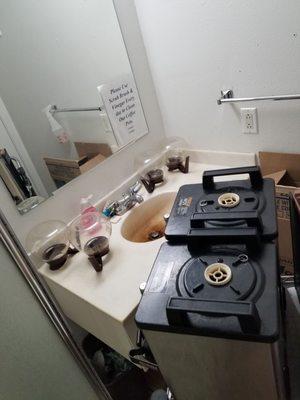 Cleaning the coffee machine in a dirty bathroom