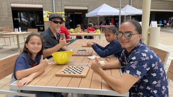 Dad & kids playing KONANE.