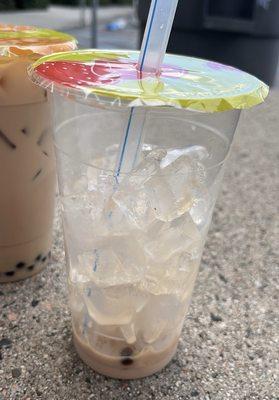 a nearly empty cup of milk tea boba w/ mostly ice leftover (about 3/4 of the cup)