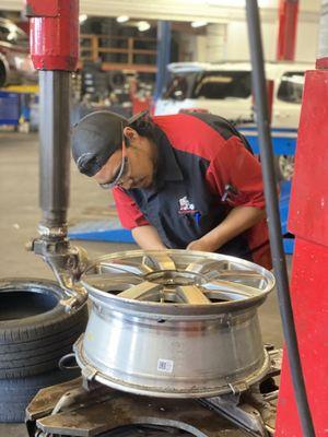 Brandon Kuhns preparing the surface of the wheel for a tire replacement.