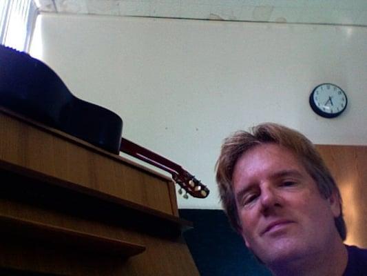 Robbie with guitar and piano at a local school