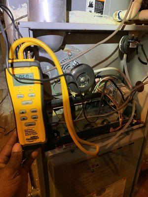 Testing the operation of a pressure switch on a gas furnace.