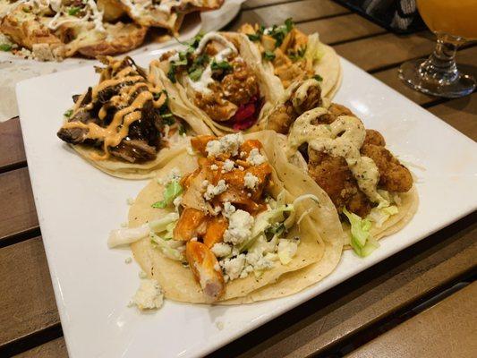 Shareable tacos- top left to right pork barn mi, tika taco, honey sriracha bottom left to right- buffalo chicken, po' boy