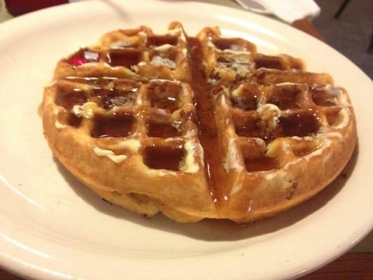 Pecan waffle up close with creamy butter and syrup. Must-havee