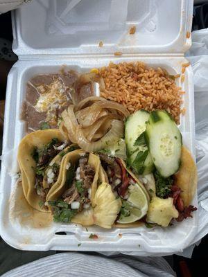 Carnitas and al pastor tacos with rice and beans.