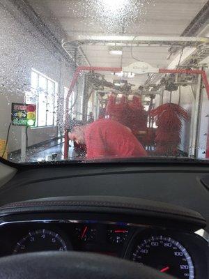 Attendant scrubbing the bugs and mud off the front