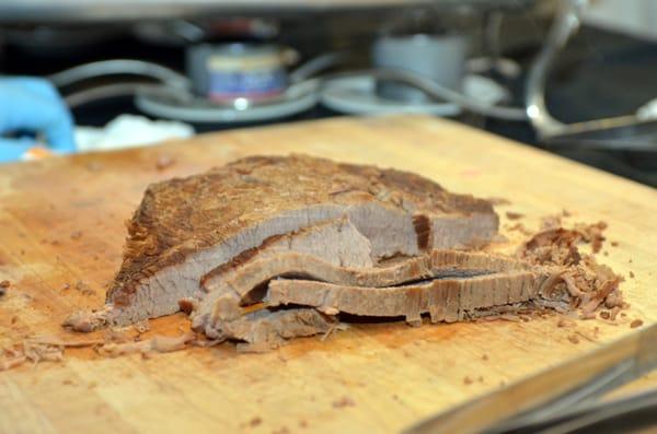 slow cooked beef brisket carved by chef with wine glaze sauce (not seen)