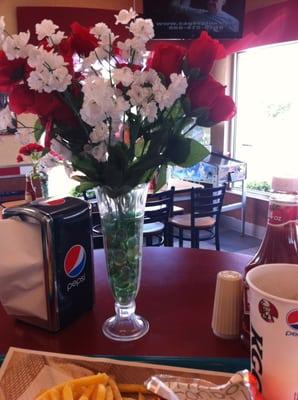 Napkins, salt, pepper, and ketchup right on the table. The artificial flowers are also a nice touch.