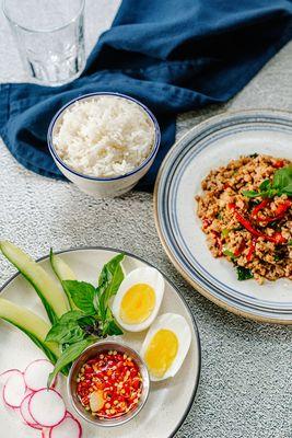 Minced chicken with basil sauce serve with a side of veggies and 6 mins egg and chili fish sauce