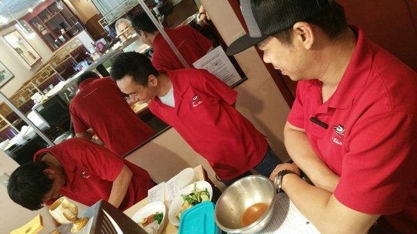 Chef Tony's co-workers watch and learn as he crafts our Poké Bowls.