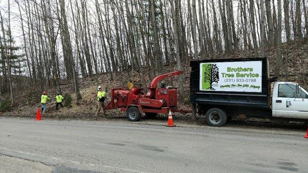 The crew uses all required safety set up while working along the road.