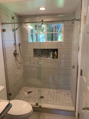 Frameless barn door shower enclosure