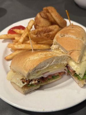 Turkey Club with fries and onion rings.