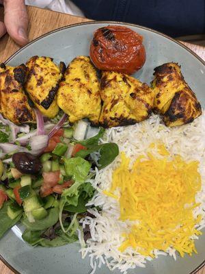 Chicken kebab with rice and salad.