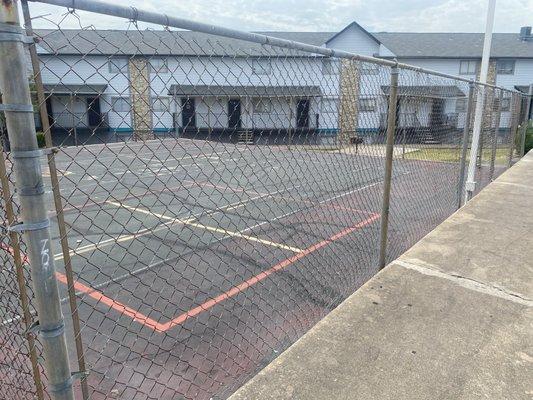 Poorly maintained area for kids to play in next to tennis court.