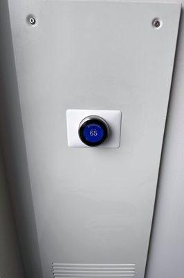 Mounted and programmed a stainless steel Nest Learning Smart Thermostat on a white Wall Plate.