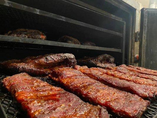 Ribs!  After a healthy application of our own dry rub, they are pampered and smoked, at low heat, until they reach tender perfection.