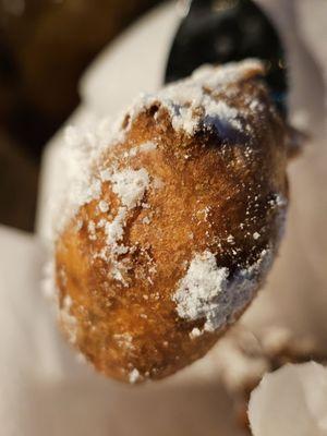 Close-up of a black plastic fork holding a fried Oreo.