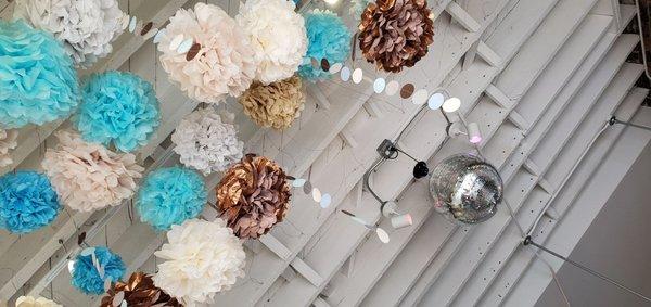 Pom pom ceiling with disco ball sets the stage for fun!