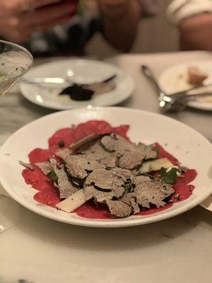 Generous amount of Black Truffle on Beef Carpaccio with Arugula and Shaved Parmesan