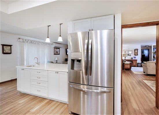 Kitchen remodel with quartz counters, cabinets, lighting and wood floors.