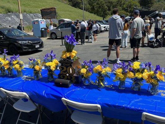 Arrangements of roses mums, blue dyed baby's breath and iris for our Cal blue and gold themed event