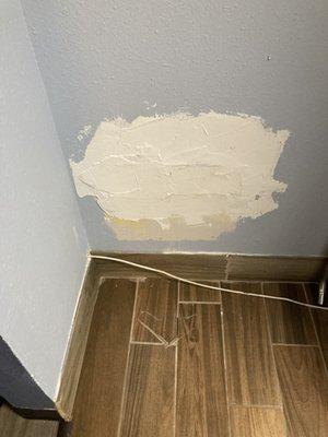 Patched area with satellite cable running directly through wall in the closet.