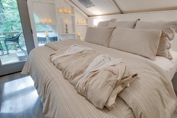 The inside of one of six on-site climage controlled glamping tents featuring private bath, kitchenette and deck.