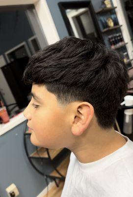 Boy's haircut, with texture on top and tapered side burns