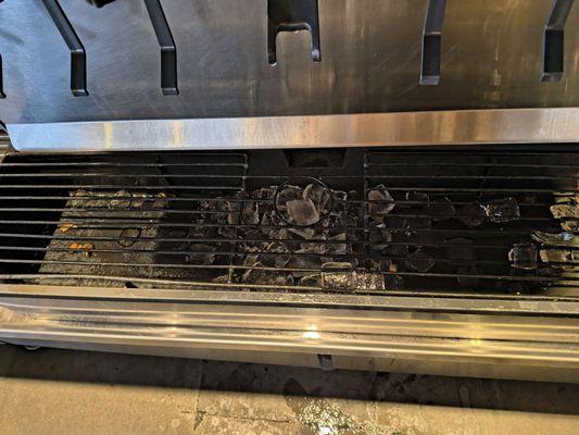 Food in the overflow tray of the soda machine.