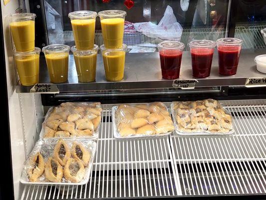 Display case. Mango and strawberry lassi on top. Unknown items on bottom.