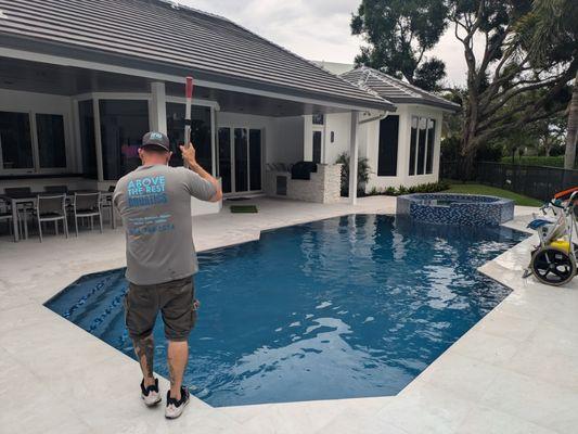 Service tech cleaning a new remodeled pool