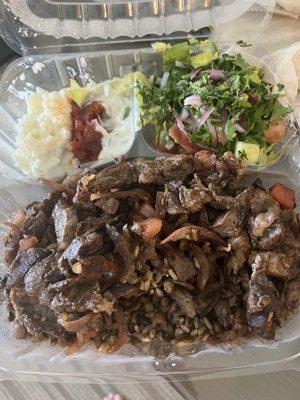 Lamb and beef platter with salad and garlic, fire, and tzaziki spreads