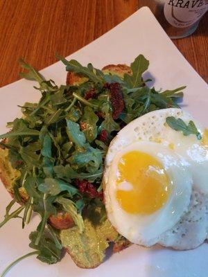 Krave Avocado Toast So fresh and healthy! arugula,sundried tomatoes, and 2 over meidium eggs on top