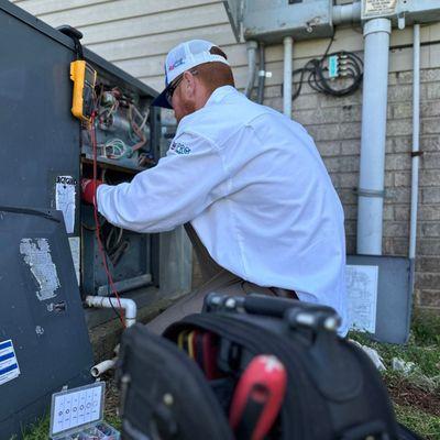 Petitt Heating & Cooling technician working on a unit.