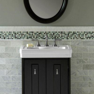 Bathroom tile details. In this photo: Natural stone subway tiles, chair rails, and mosaic accent border. View these in our store!